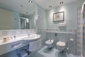 a bathroom with a sink and a toilet and a mirror at Hotel Rivalago in Sulzano