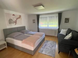 a bedroom with a bed and a couch at InNatura Velden in Velden am Wörthersee +27 photos