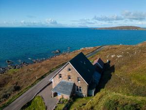 an aerial view of a house on a hill next to the ocean at Gairloch Sands Youth Hostel in Gairloch +21 photos
