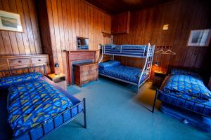 a bedroom with two bunk beds and a fireplace at Gairloch Sands Youth Hostel in Gairloch