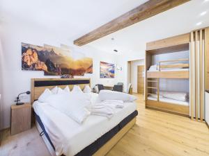 a bedroom with a large bed and bunk beds at LUMA Stubai Aparthotel - Neueröffnung inklusive STUBAI SUPER CARD in Neustift im Stubaital +87 photos