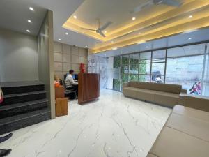 a lobby of a building with people sitting at a counter at Hotel Vishwaraj Residency in Solapur