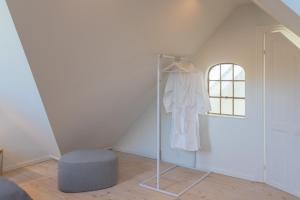 a room with a closet with a white shirt and a window at Sjælegård Countryside Lodge in Allinge +79 photos
