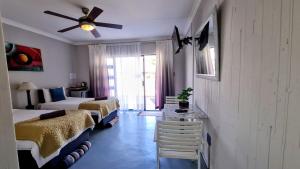a bedroom with two beds and a ceiling fan at Kaleaba House on the Riverside in Parys