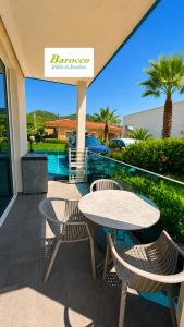 a patio with a table and chairs on a balcony at Barocco Villa & Studios in Potamiá