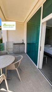 a balcony with a table and chairs and a bed at Barocco Villa & Studios in Potamiá