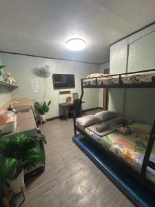 a room with two bunk beds and a desk at Frogman inn in Puerto Princesa City