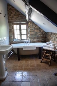 a bathroom with a large tub and a sink at The Ebrington Arms in Chipping Campden