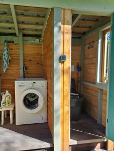 a washing machine in a cabin with a toilet at Kooti Ait in Korjuse