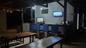 a bar with wooden tables and blue chairs at FURUSATO BUNGALOW Gili Gede in Gili Gede