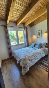 a bedroom with a bed with a comforter and two windows at Malownicza Dolina in Wapnica +64 photos