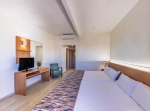 a hotel room with a bed and a tv at Hotel Alone in Cala de Finestrat