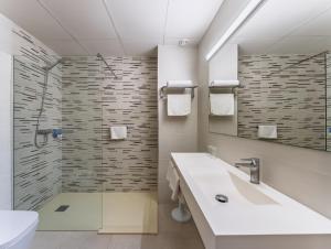 a bathroom with a shower and a sink and a mirror at Hotel Alone in Cala de Finestrat +12 photos