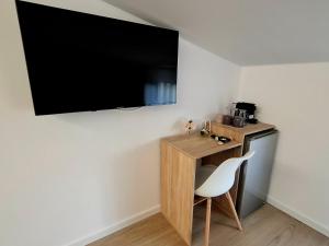 a small desk with a chair and a television on a wall at Maracas Sea View Boutiq in Costinesti