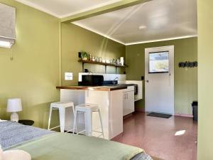 a kitchen with a counter and two stools in a room at Mt Dobson Motel in Kimbell