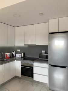 a kitchen with white cabinets and a stainless steel refrigerator at Basia in Torrevieja