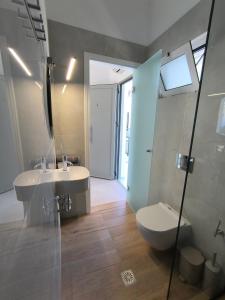 a bathroom with a sink and a toilet and a shower at Ioannis Fotinos Rooms in Lygia +3 photos