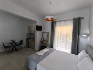 a bedroom with a bed and a table and a window at Ioannis Fotinos Rooms in Lygia
