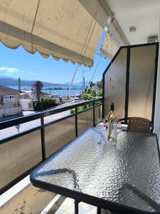 a bottle of wine sitting on a table on a balcony at Ioannis Fotinos Rooms in Lygia
