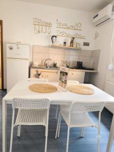 a kitchen with a white table and chairs at Smestaj Dzentlmen in Soko Banja