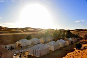 a group of white tents in the desert at Camel Trekking Camp & Activities in Merzouga