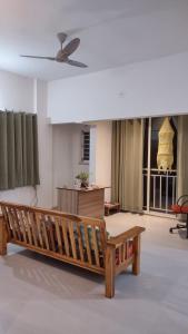a living room with a wooden bench and a ceiling at SRUSHTI The Peace Home HOME STAY in Kolhapur
