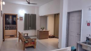 a living room with a chair and a table at SRUSHTI The Peace Home HOME STAY in Kolhapur