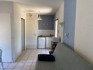a living room with a couch and a kitchen at Meublé BLEU in Réaumur