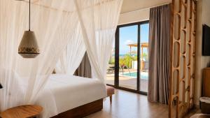 a bedroom with a bed and a view of a pool at ENVI Paje Wellness Lodge in Paje +93 photos