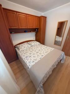 a small bedroom with a bed and wooden cabinets at Apartman Pijuk in Slatine