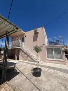 a house with a staircase and a bench in front of it at Apartman Pijuk in Slatine