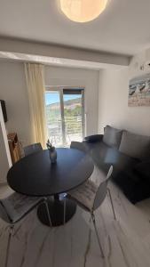 a living room with a black table and chairs at Apartman Pijuk in Slatine