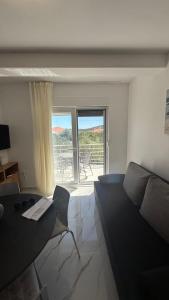 a living room with a couch and a table at Apartman Pijuk in Slatine