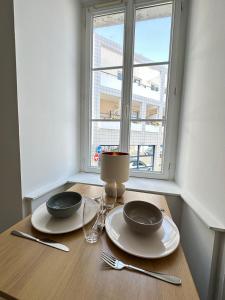 a table with two plates and glasses and a window at Halles in Les Sables-d'Olonne