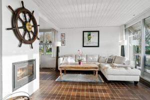 a living room with a couch and a table at Main House - Rolsø Retreat in Knebel