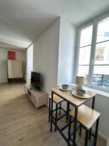 a living room with a table and a tv at Halles in Les Sables-d'Olonne