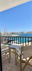 a balcony with picnic tables and a view of the water at Hotel Lito in Tinos