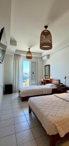 a hotel room with two beds and a window at Hotel Lito in Tinos