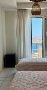 a bedroom with a bed and a large window at Hotel Lito in Tinos +43 photos
