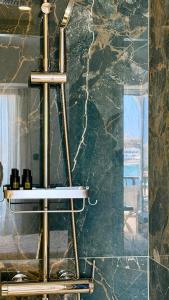 a metal shelf in a bathroom with a marble wall at Hotel Lito in Tinos