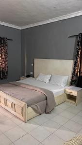 a bedroom with a large bed with a wooden frame at Diamond Hotel Lagos in Lagos