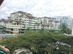 a large building with trees in front of it at Zoomma Marina Court Condo in Kota Kinabalu