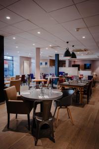 a dining room with tables and chairs in a restaurant at Campanile PRIME - Dijon Centre Gare in Dijon