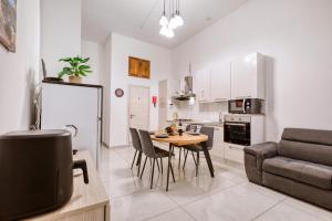 eine Küche und ein Wohnzimmer mit einem Tisch und einem Sofa in der Unterkunft Heart of Gozo - Modern Rooms in shared Apartment - Victoria D-Central opposite Duke Shopping Center in Victoria