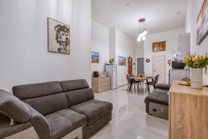 ein Wohnzimmer mit Sofa und Tisch in der Unterkunft Heart of Gozo - Modern Rooms in shared Apartment - Victoria D-Central opposite Duke Shopping Center in Victoria