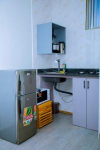 a kitchen with a stainless steel refrigerator and a counter at ExtraMile Apartments - Cozy Studio in Dodoma +15 photos