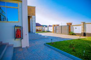 a house with a brick walkway next to a yard at ExtraMile Apartments - Cozy Studio in Dodoma