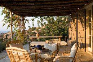 a table and chairs on a patio with a view of the ocean at Aphrodite's Oasis in Pomos