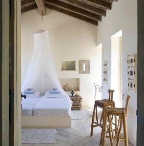 a white bedroom with a bed with a canopy at Aphrodite's Oasis in Pomos