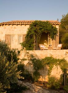 a stone house with a table and chairs at Aphrodite's Oasis in Pomos